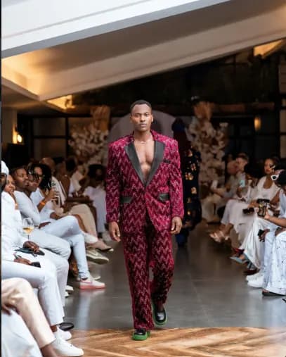A model on the runway in a magenta patterned suit at a YG Fashion Agency show